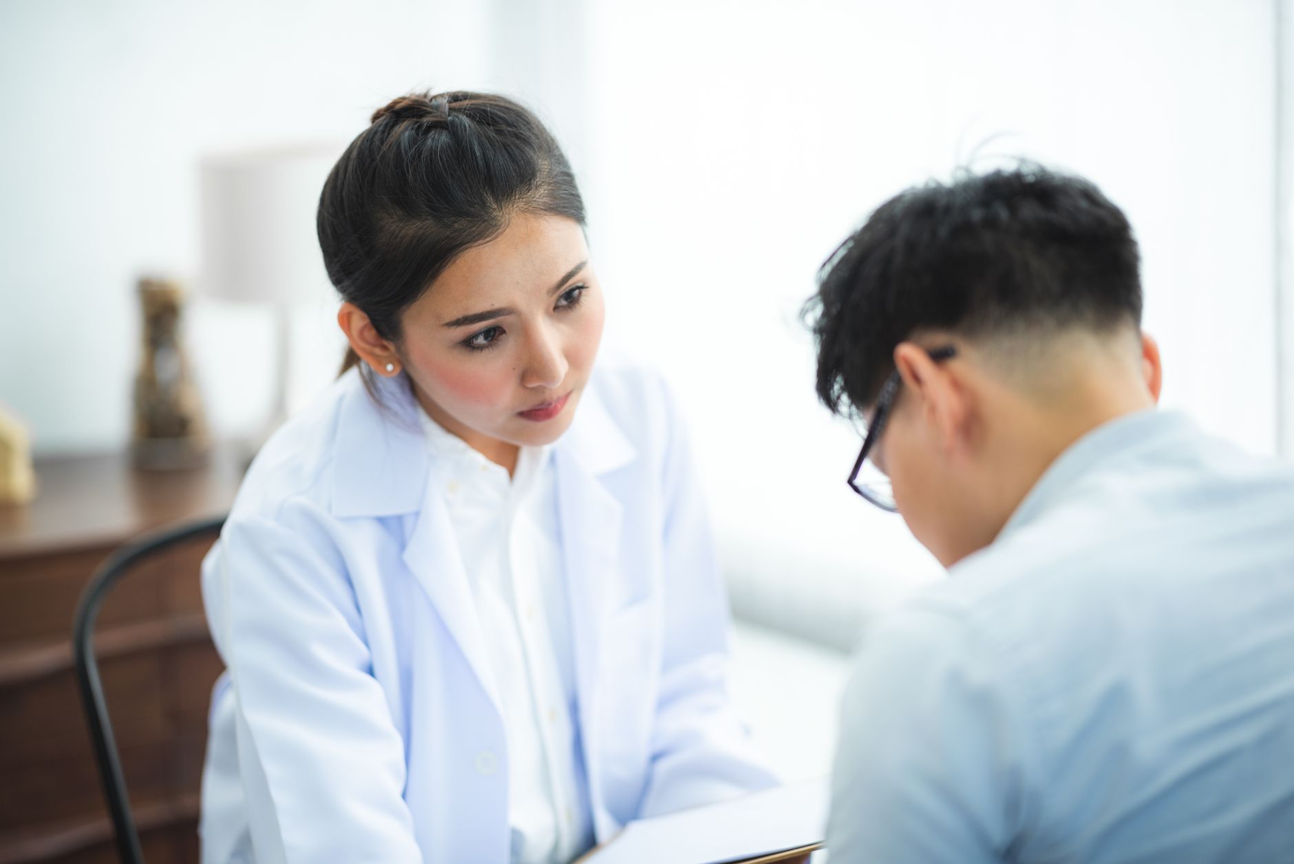 A male patient having a private consultation with a doctor in a modern clinic office