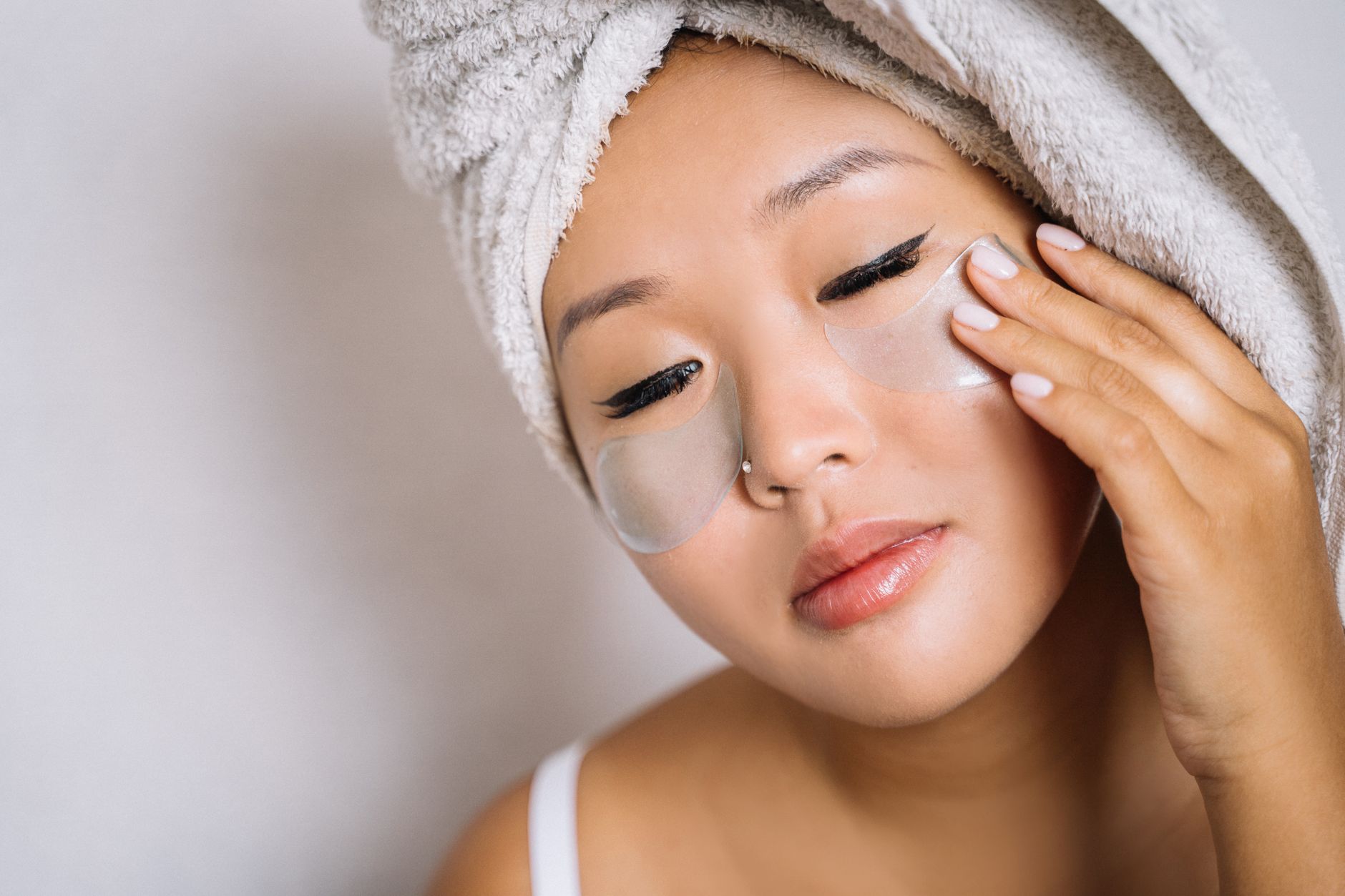 Close-up of a woman's eyes and smooth under-eye area in soft natural light, representing lower eyelid rejuvenation
