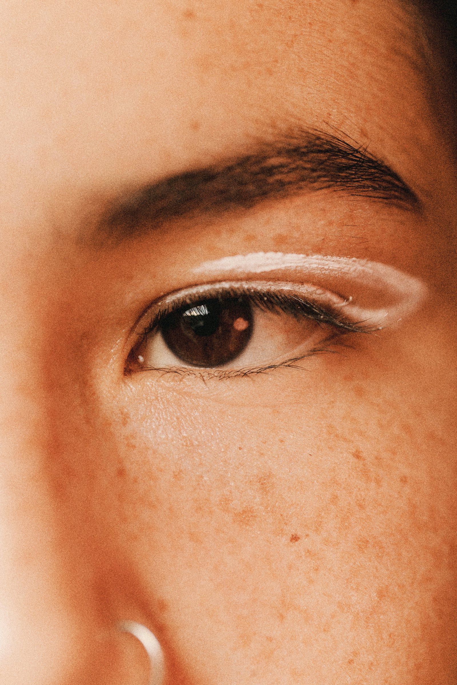 Extreme close-up of a single eye and eyelid crease.
